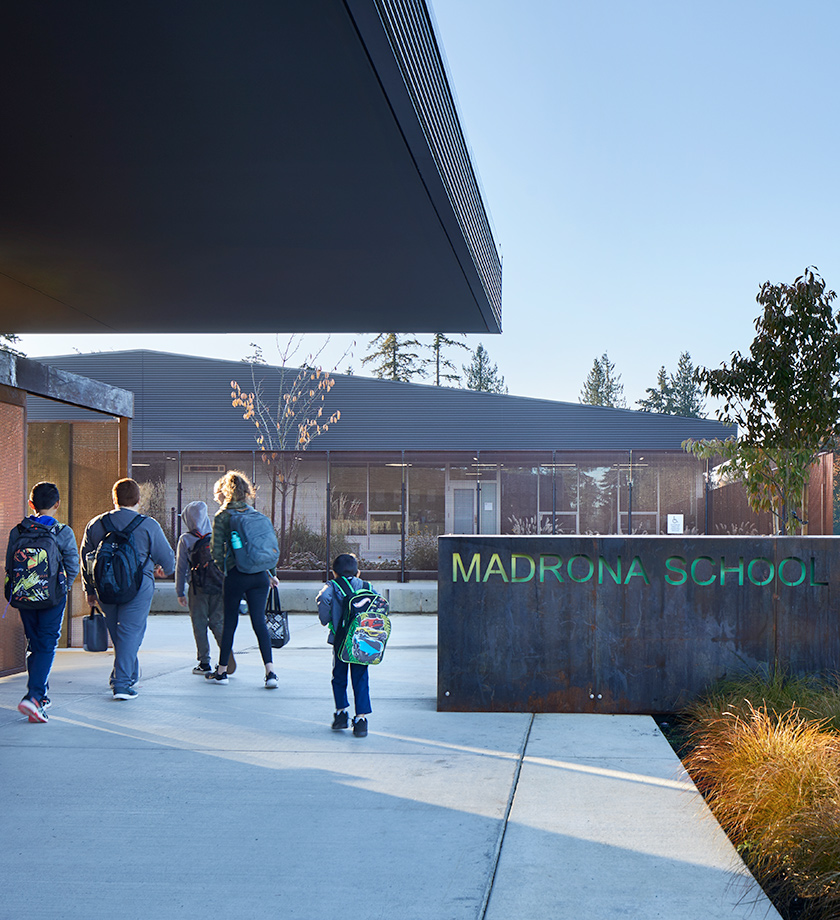 Students walking by a Madrona School sign at the main entry.