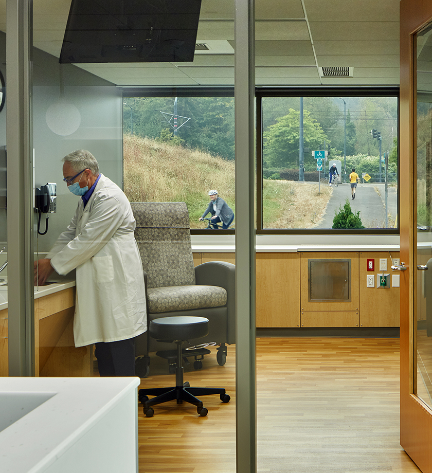 A doctor washing his hands in a home training room with views to a bicycle trail