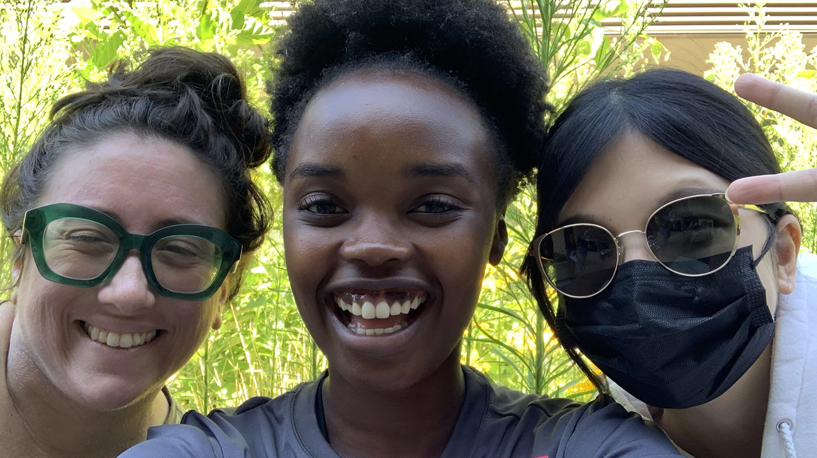 A photo of three women smiling happily for the camera